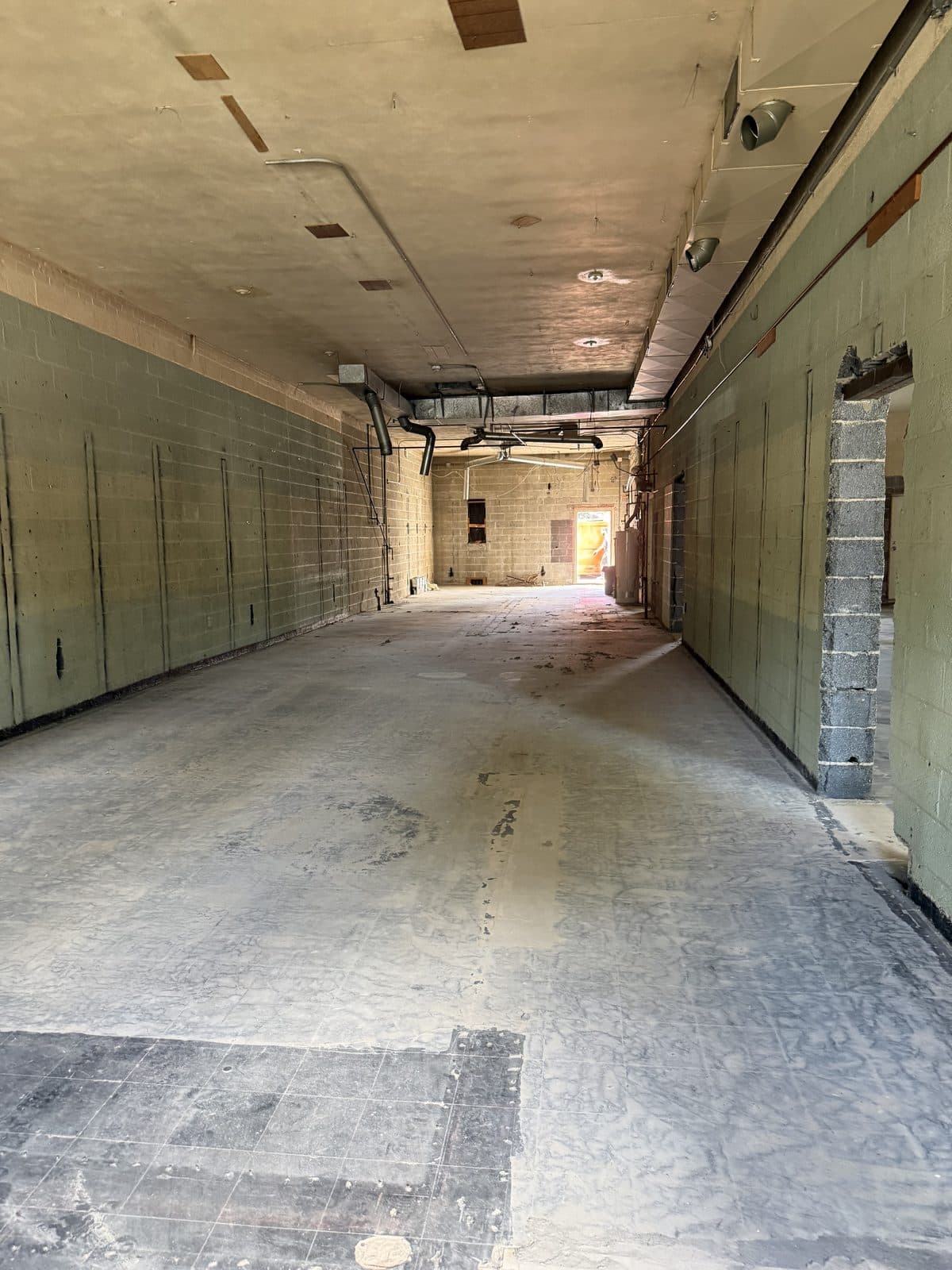 A long open span of bare block wall and concrete floor where partitions and offices were removed.