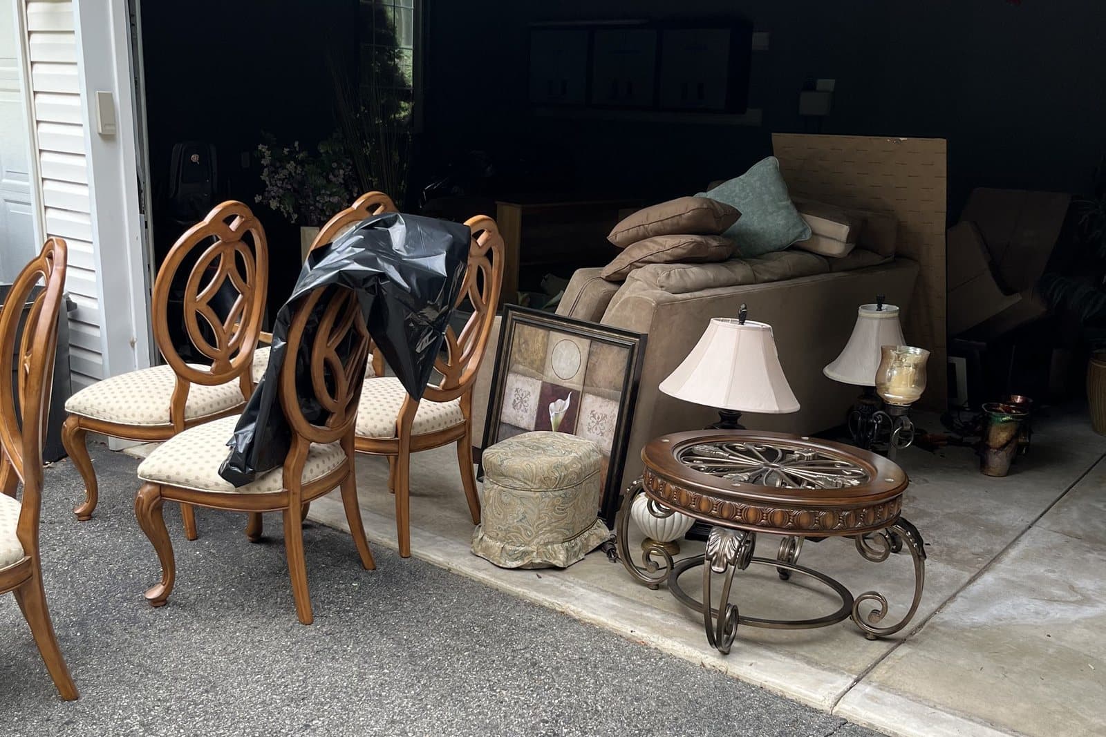Furniture and household items moved out of a garage during a residential cleanout.